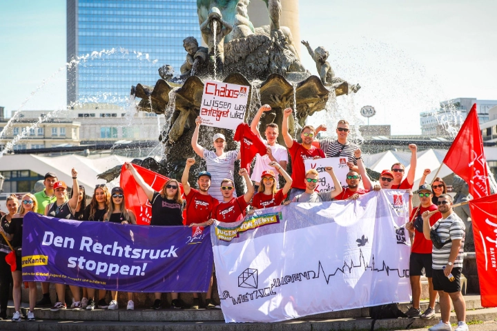 eine Gruppe der IG Metall Jugend posiert mit Bannern auf der FairWandel-Kundgebung vor einem Brunnen in Berlin 